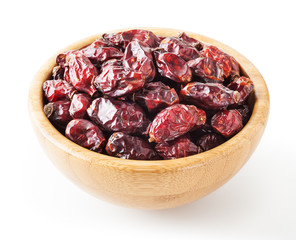 Dried wild rose berries in wooden bowl isolated on white background with clipping path