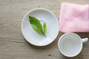 Close up woman hand cleaning coffee cup on the morning with microfiber cloth,Close up woman hand cleaning coffee cup on the rustic wood table.