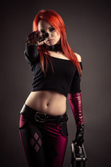 sensual woman in suit with gun in hands