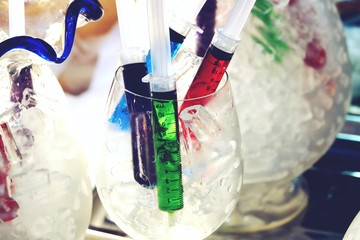 Many colorful Fresh juice in syringe on ice