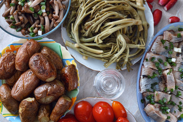 Baked potato, pickled herring, marinated tumbleweed and mushrooms, glass of vodka