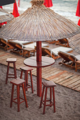 Beach bar with thatched umbrellas and a wooden terrace at an exotic resort, summer concept