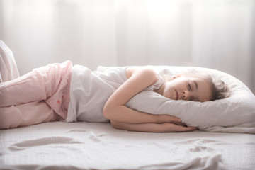 Obraz na płótnie Canvas Cute little girl sleeps sweetly in bed