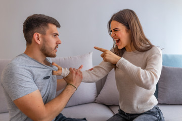 Furious couple arguing while having problems in their relationship. Stop annoying me! Angry woman arguing with her husband at home. Couple Having Argument At Home