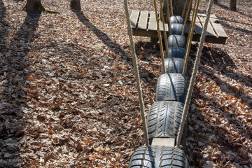 Swinging road of old tires the detail of rope climbing path frame for children and adults in climbing the rope park at the sunny day - Powered by Adobe