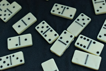 Some dominoes pieces thrown on a black background