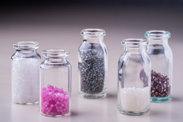 Varied colors beads in transparent bottles white background