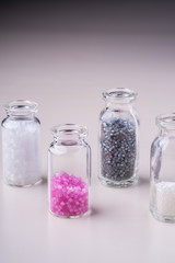 Varied colors beads in transparent bottles white background