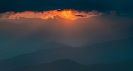Obraz premium Orange Light Breaks thick Clouds