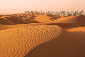 Dunes of Desert at dawn and skyscrapers of  Dubai (United Arab Emirates)