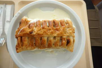 Delicious apple strudel with custard and fruit salad in a canteen in Germany