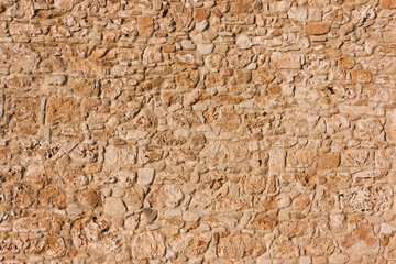 abstract  brown, sandy, old wall of a stone house in the open air.