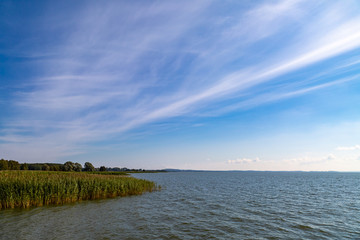ein See bei Sonnenschein, blauer Himmel mit Wolken	