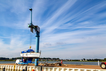 ein großes Boot wird mit einem Kran ins Wasser gesetzt