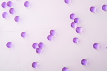 Purple scattered marbles on white background top view