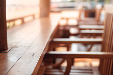 Close up view of wood surface with flare. Empty tables and chairs blur in the coffee shop.