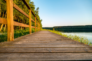 Obraz premium ein See mit Holzsteg umgeben von Wald 