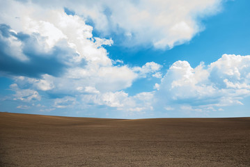 Empty brown soil of field and blue sky for natural background