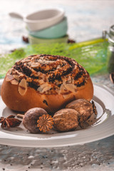 Few poppy heads on white plate with sweet baked bun and spices