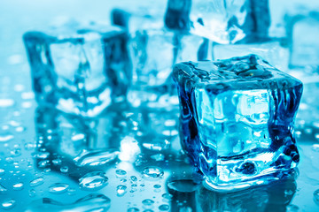 ice cubes wet with water drops on blue background