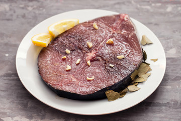 fresh tuna with lemon on white plate