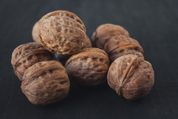  A lot of walnuts on a black background. A bunch of nuts