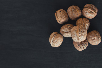  A lot of walnuts on a black background. A bunch of nuts