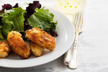 fried squid with salad and lemon on white plate
