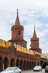 Fototapeta na wymiar Old yellow U-Bahn subway train crossing the famous Oberbaum Bridge (Oberbaumbrucke) in Berlin, Germany.