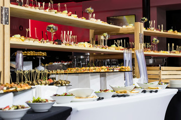 Banquet buffet with snacks delicacies cheese canapes desserts.