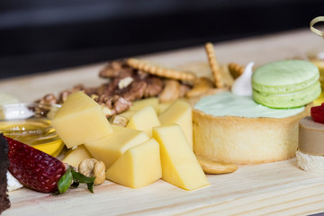 Cheese plate close-up with several varieties of fruit and honey cheese.