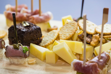 Cheese plate close-up with several varieties of fruit and honey cheese.