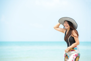 Summer Holiday.  Lifestyle smiling asian woman wearing bikini fashion summer trips relax on the sandy ocean beach. Happy woman enjoy and relax vacation. Lifestyle and Travel Concept