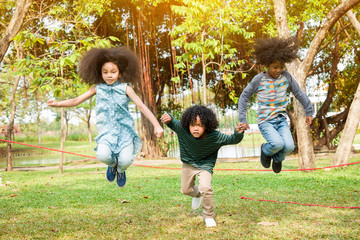 Children jumping over the rope in the park © amorn