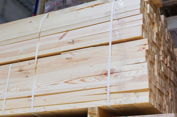 Wooden bars in a pack. Stacked wooden bars fence on a lumber yard. Construction Materials.