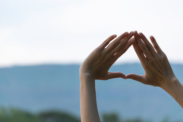 Hands of person making frame distance or symbol in nature.