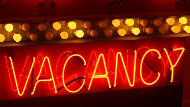 An illuminated, seamless looping, neon sign that reads, &ldquo;Vacancy&rdquo;