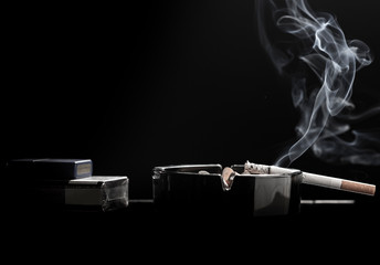 Closeup of cigarette on ashtray with a beautiful wisp of smoke