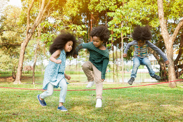Children jumping over the rope in the park