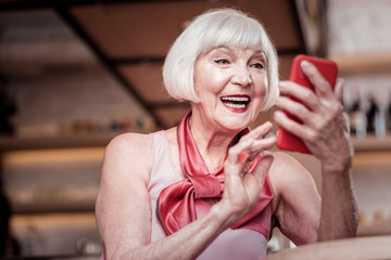 Beautiful stylish old lady with short haircut checking social media