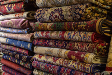 Beautiful Persian and Afghanistan rugs or carpets for sale on shelves at Global Village creating a nice background