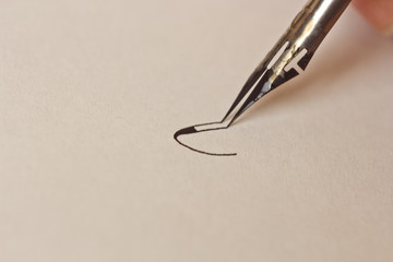 hand writes with the inky pen on a white paper sheet with stripes. stationery on desk close up top...