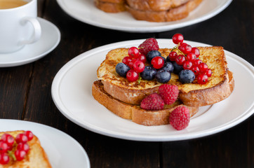 Traditional French toast with berries: blueberries, currant, raspberries  and icing sugar for perfect  sweet breakfast. Delicious dessert background.