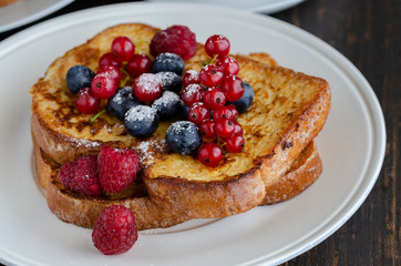 Close up of French toasts with fruit on the plate. Restaurant menu image.