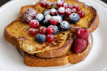 Close up of French toasts with fruit on the plate. Restaurant menu image.