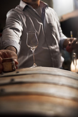wooden barrel on a dark background, in a workshop, in an old room. production of barrels for cognac and wine, in a low key