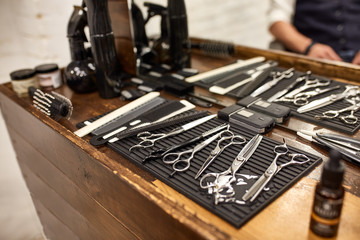 barber tools on wooden shelf and mirror in barbershop