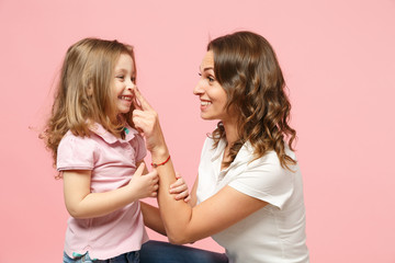 Woman in light clothes have fun with cute child baby girl. Mother, little kid daughter isolated on pastel pink wall background, studio portrait. Mother's Day, love family, parenthood childhood concept