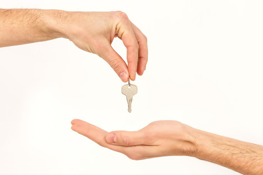 Man's hand holds a key isolated on a white background