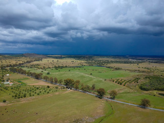 Naklejka premium Aerial view of a farm field with storm clouds in background. Alentejo Portugal